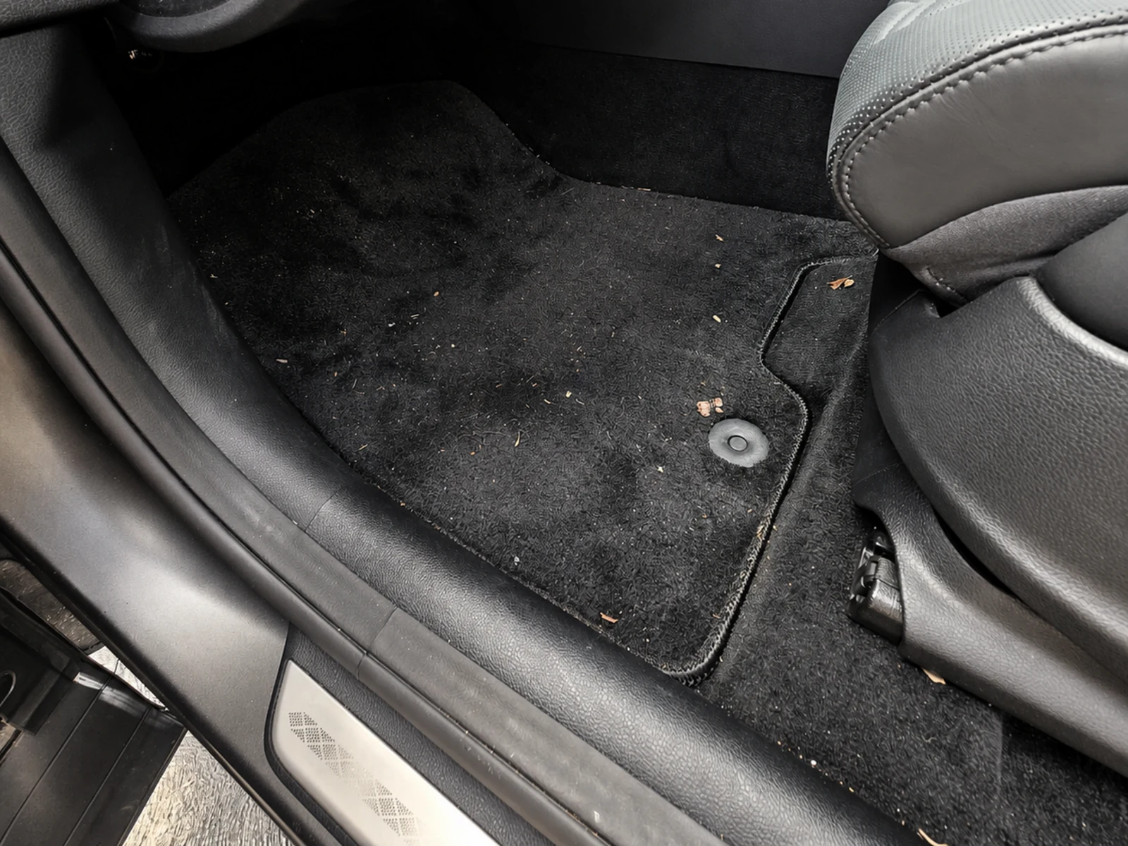 Vehicle carpet before detailing, showing dirt and marks